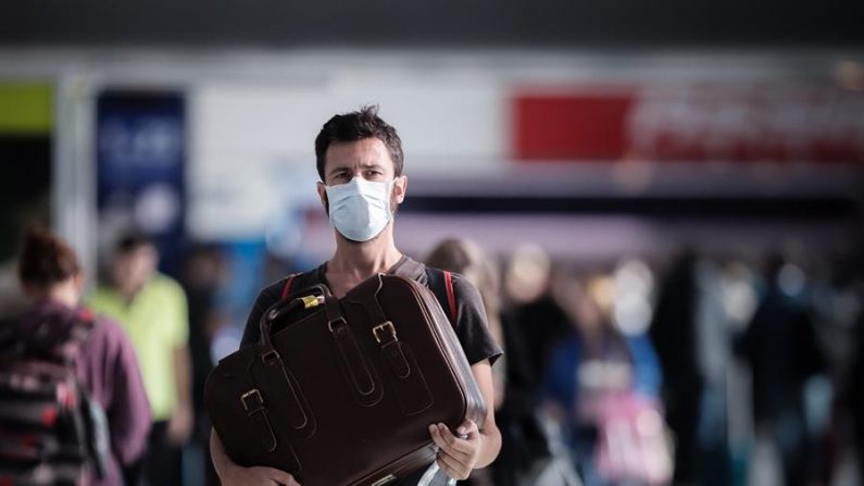 Pasajeros usan cubrebocas para protegerse del coronavirus mientras transitan por el Aeropuerto Internacional de Ezeiza en Buenos Aires. EFE/Juan Ignacio Roncoroni
