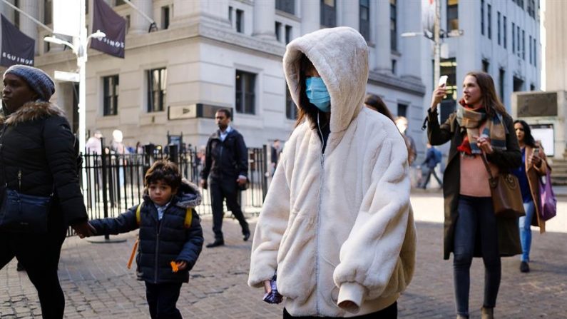 Una persona con una máscara facial pasa por la Bolsa de Valores de Nueva York, EE.UU., 03 de marzo de 2020. EFE/EPA/Justin Lane
