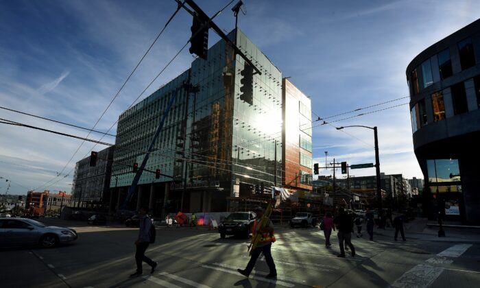 Varias personas caminan por delante de parte del nuevo complejo de la sede central de Amazon que se está construyendo en el centro de Seattle, Washington, el 44 de septiembre de 2015. (MARCAR RALSTON/AFP vía Getty Images)