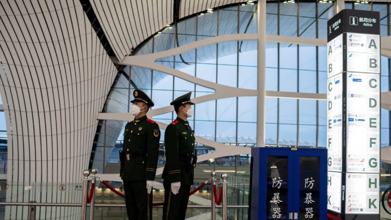 Foto tomada el 14 de febrero de 2020 donde se muestra a policías paramilitares chinos con máscaras protectoras mientras vigilan un área en el aeropuerto internacional de Daxing en Beijing. (Nicolas Asfouri/AFP a través de Getty Images)