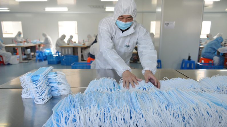 Un trabajador de una fábrica en Nanjing, en la provincia china de Jiangsu clasifica máscaras faciales, el 18 de febrero de 2020. (STR/AFP vía Getty Images)