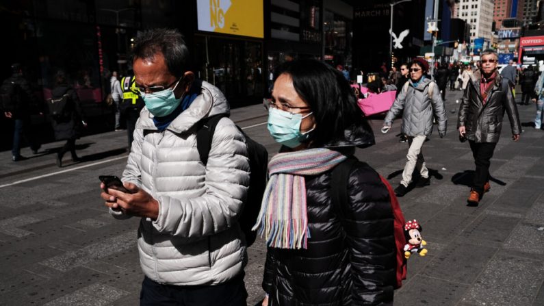 Personas caminan por Manhattan con máscaras quirúrgicas mientras los temores de que el coronavirus se propague a través de Estados Unidos aumentan en la ciudad de Nueva York, el 4 de marzo de 2020. (Spencer Platt / Getty Images)