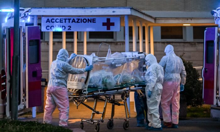 Trabajadores médicos en overol llevan a un paciente en cuidados intensivos al recién construido hospital temporal del Hospital Gemelli en Roma, Italia, el 16 de marzo de 2020. (Andreas Solaro/AFP a través de Getty Images)
