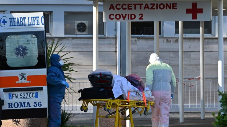 Enfermeras con máscaras y overoles llevan a un paciente en camilla al hospital temporal, Columbus Covid 2, recientemente construido para combatir la nueva infección por coronavirus, en el hospital Gemelli, en Roma, el 16 de marzo de 2020. (Andreas Solano/AFP a través de Getty Images)
