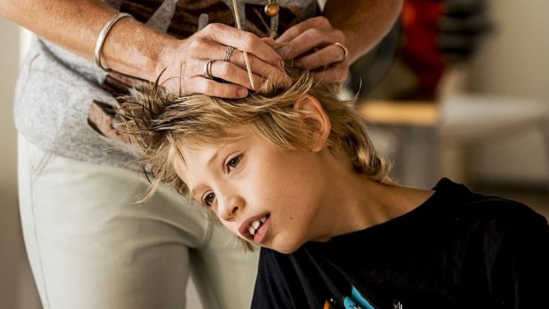 Una madre controla el cabello de su hijo para ver si está infestado de piojos en una escuela primaria de Scheveningen, el 31 de agosto de 2016. (REMKO DE WAAL/AFP/ Getty Images)
