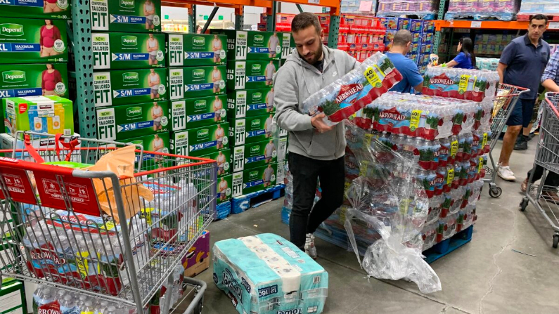 Un hombre compra agua, comida y papel higiénico en una tienda en Los Ángeles el 29 de febrero de 2020. (Mark Ralston / AFP a través de Getty Images)