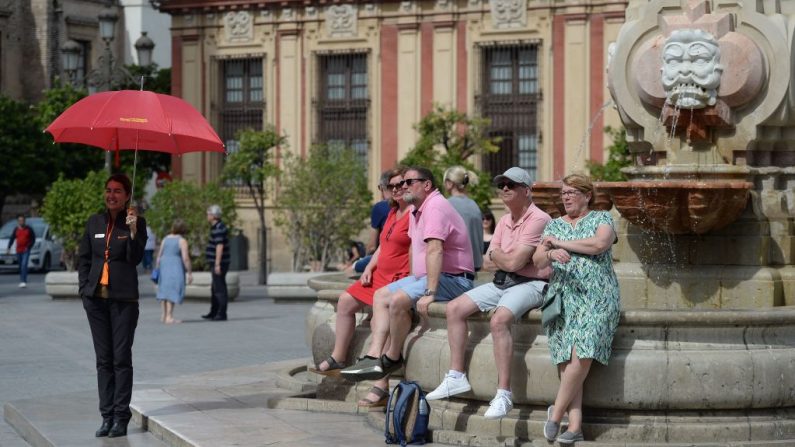 Los turistas visitan Sevilla el 11 de marzo de 2020 después de que España prohibiera todo el tráfico aéreo de Italia, cerrara las escuelas y bloqueara a los aficionados a los partidos de fútbol debido al brote de coronavirus. (CRISTINA QUICLER/AFP vía Getty Images)