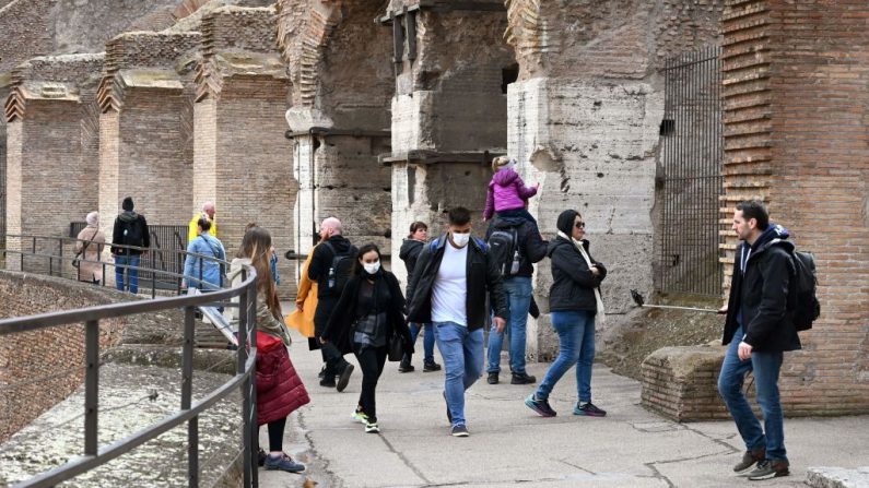 Los turistas con máscaras respiratorias visitan el Coliseo de Roma (Italia) el 6 de marzo de 2020. (TIZIANA FABI/AFP/Getty Images)