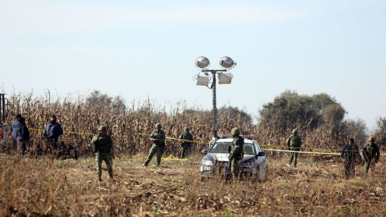 Miembros de la Policía Federal y soldados registran la escena el 25 de diciembre de 2018 de un accidente de helicóptero en el que la gobernadora del estado mexicano de Puebla, Martha Erika Alonso, y su esposo, el senador y ex gobernador de la misma región, Rafael Moreno, murieron el 24 de diciembre cuando el helicóptero cayó en picado al suelo en San Pedro Tlaltenango después de despegar de la cercana ciudad de Puebla (México). (JOSE CASTANARES/AFP vía Getty Images) 