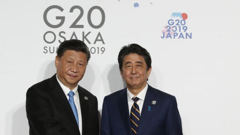 El líder chino Xi Jinping es recibido por el primer ministro japonés Shinzo Abe para una sesión de fotos en el primer día de la cumbre del G20, el 28 de junio de 2019 en Osaka, Japón. (Kim Kyung-Hoon - Pool/Getty Images)