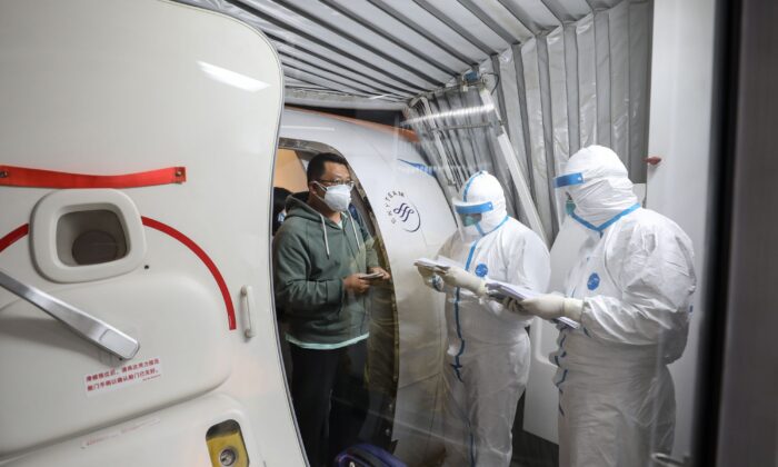 Un hombre (izquierda) descendiendo de un avión de Xiamen Airlines en el aeropuerto de Tianhe en la ciudad de Wuhan, provincia de Hubei, China, el 31 de enero de 2020. (STR/AFP a través de Getty Images)
