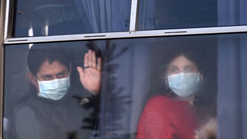 Los evacuados de China afectados por el coronavirus miran desde un autobús cuando salen del aeropuerto de Járkov (Ucrania) el 20 de febrero de 2020. (SERGEI SUPINSKY/AFP vía Getty Images)