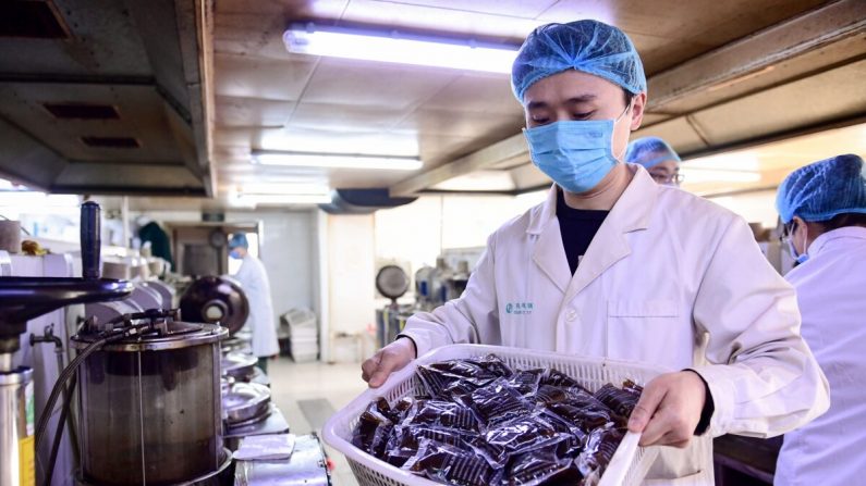 Un trabajador médico sostiene bolsas de medicina tradicional china líquida en un hospital en Shenyang, China, el 20 de febrero de 2020. (STR/AFP a través de Getty Images)