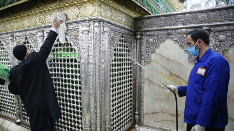 Trabajadores sanitarios iraníes desinfectan el santuario de Masumeh de Qom el 25 de febrero de 2020 para prevenir la propagación del coronavirus. (MEHDI MARIZAD/FARS NEWS AGENCY/AFP vía Getty Images)