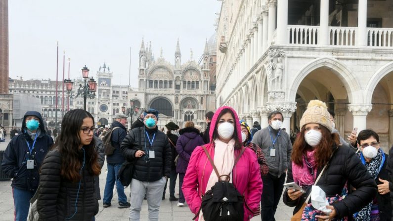 Los turistas con máscaras protectoras visitan Venecia, Italia, el 25 de febrero de 2020, durante el período habitual de las festividades del Carnaval que se han cancelado tras un brote del nuevo coronavirus COVID-19 en el norte de Italia. (ANDREA PATTARO/AFP via Getty Images)