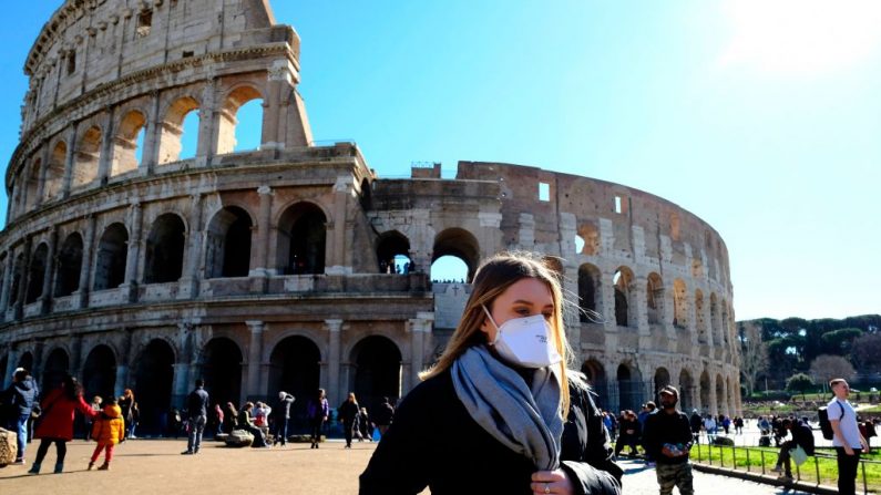 Una turista con una máscara respiratoria protectora visita el exterior del monumento del Coliseo en el centro de Roma el 28 de febrero de 2020 en medio del temor a la epidemia de Covid-19. (ANDREAS SOLARO/AFP vía Getty Images)