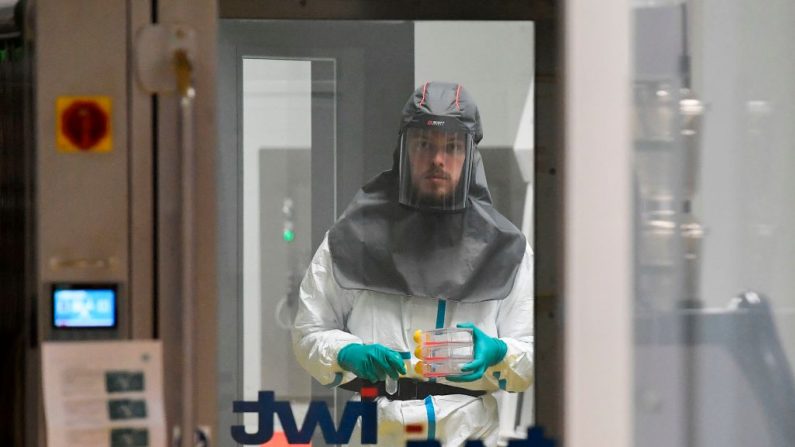 Un virólogo que trabaja en la búsqueda de un tratamiento contra el COVID-19, el novedoso coronavirus, sostiene muestras en un laboratorio de nivel 3 en el Instituto Rega de Investigación Médica de la Universidad de Lovaina (Bélgica), el 28 de febrero de 2020. (JOHN THYS/AFP/Getty Images)