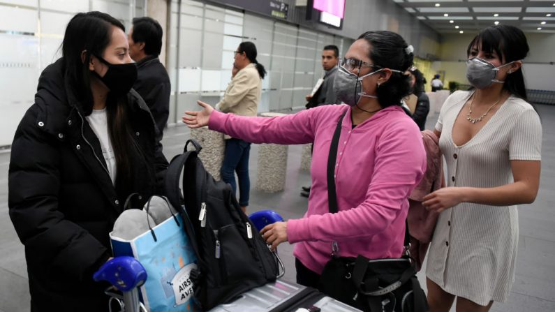 Los pasajeros de un vuelo que se originó en Corea del Sur llevan máscaras protectoras para la cara al aterrizar en el aeropuerto internacional de Ciudad de México, el 28 de febrero de 2020, mientras el nuevo coronoavirus, COVID-19, se propaga por todo el mundo. (Foto de ALFREDO ESTRELLA/AFP vía Getty Images)
