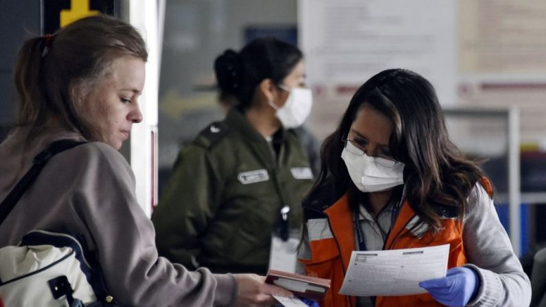 El personal del aeropuerto usa máscaras protectoras en el aeropuerto internacional de El Alto-La Paz, en Bolivia, el 28 de febrero de 2020, mientras el virus del PCCh se propaga por todo el mundo. (Foto de AIZAR RALDES/AFP vía Getty Images)
