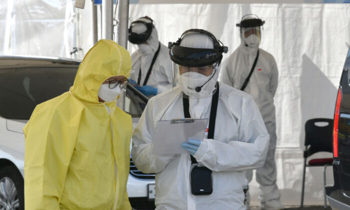 Médicos con equipo de protección revisan a conductores con síntomas sospechosos del nuevo coronavirus en un control móvil de pruebas de virus en Goyang, Corea del Sur, el 29 de febrero de 2020. (Jung Yeon-je/AFP vía Getty Images)