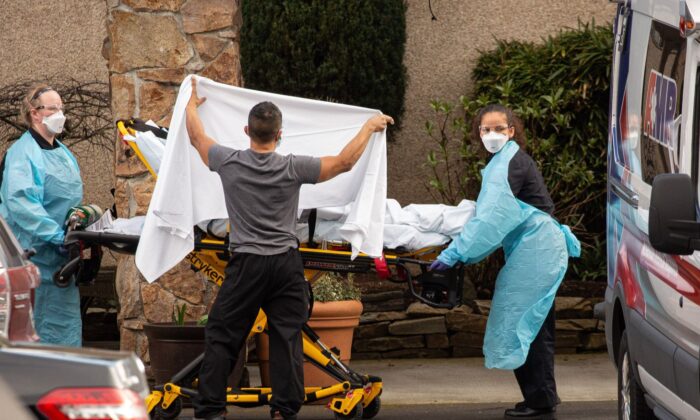 Los trabajadores de la salud transportan a un paciente en camilla a una ambulancia en el Life Care Center de Kirkland en Kirkland, Washington, el 29 de febrero de 2020. (David Ryder/Getty Images)