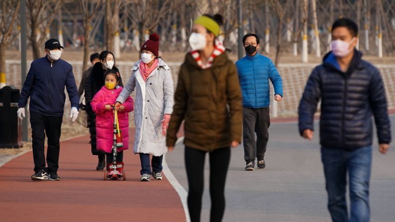Personas con máscaras caminan en un parque en Beijing el 29 de febrero de 2020. (Lintao Zhang / Getty Images)