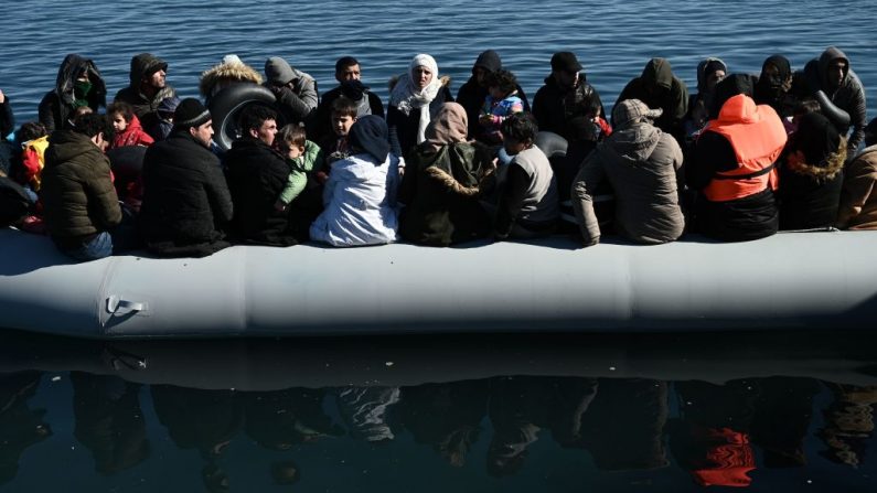 Los migrantes son vistos en un bote inflable mientras los residentes locales les impiden desembarcar en la isla de Lesbos (Grecia), el 1 de marzo de 2020. (ARIS MESSINIS/AFP vía Getty Images)