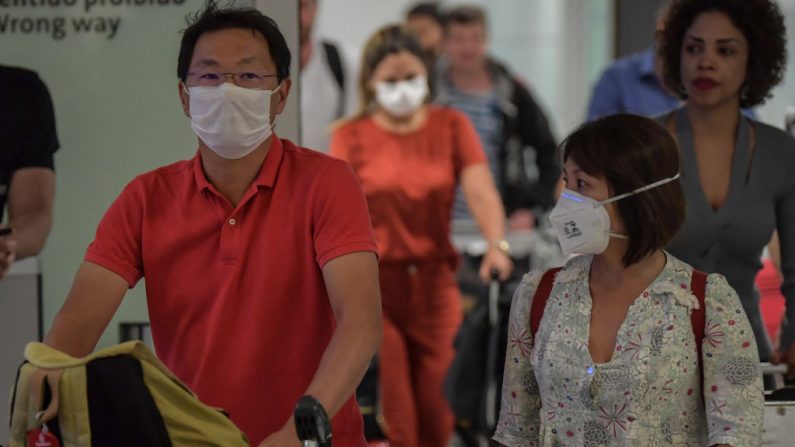 Pasajeros con máscaras como medida de precaución para evitar contraer el nuevo coronavirus COVID-19 llegan en un vuelo desde Italia al Aeropuerto Internacional de Guarulhos, en Guarulhos, Sao Paulo, Brasil el 2 de marzo de 2020. (NELSON ALMEIDA/AFP/Getty Images)