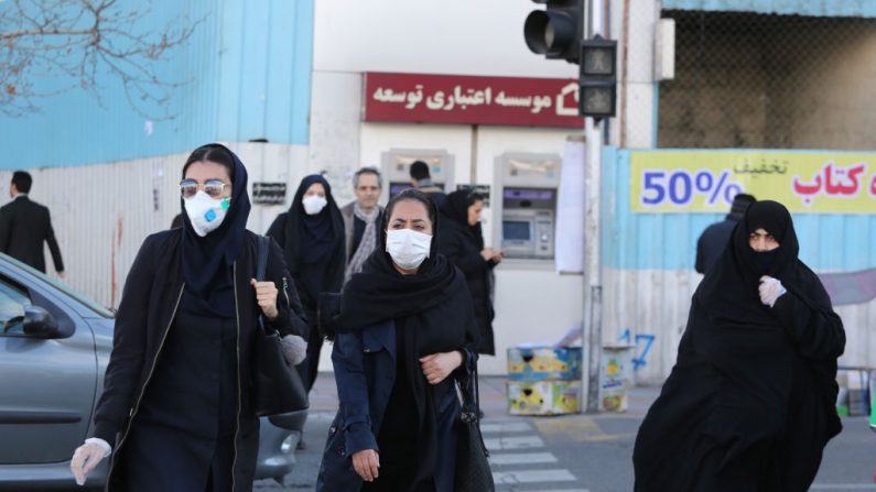 Mujeres con máscaras protectoras cruzan una calle de la capital iraní, Teherán, el 2 de marzo de 2020, tras el brote de la enfermedad COVID-19. (Foto de ATTA KENARE/AFP vía Getty Images)