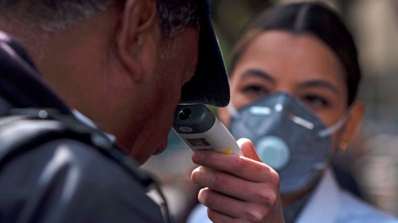 Una enfermera comprueba la temperatura de un hombre en la entrada del Hospital General de Tijuana, en Tijuana, México, el 2 de marzo de 2020. (Foto de GUILLERMO ARIAS/AFP vía Getty Images)
