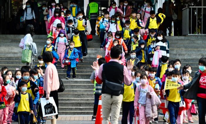 Los niños con máscaras faciales salen de su escuela primaria al final del día en el distrito de Xindian, ciudad de Nueva Taipei, el 3 de marzo de 2020. (Sam Yeh/AFP a través de Getty Images)