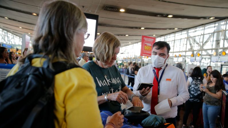 Un miembro del personal de una aerolínea usa una máscara protectora como medida preventiva contra la propagación del coronavirus COVID-19, mientras trabaja en el Aeropuerto Internacional Arturo Merino Benítez, en Santiago, el 3 de marzo de 2020. (Foto de JAVIER TORRES/AFP vía Getty Images)
