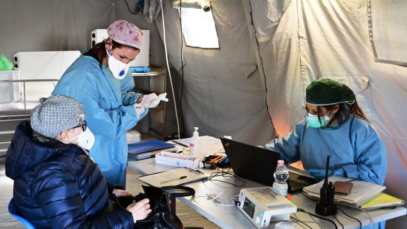 Una mujer anciana recibe asistencia en una carpa médica de pretratamiento frente al hospital de Cremona, en Cremona, en el norte de Italia, el 4 de marzo de 2020. (MIGUEL MEDINA/AFP/Getty Images)