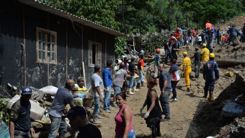 La gente participa en la búsqueda de las víctimas de un deslizamiento de tierra provocado por las lluvias torrenciales del fin de semana, en Barreira do Joao Guarda, una favela de Guaruja, a 95 km de Sao Paulo, Brasil, el 4 de marzo de 2020. (NELSON ALMEIDA/AFP/Getty Images)