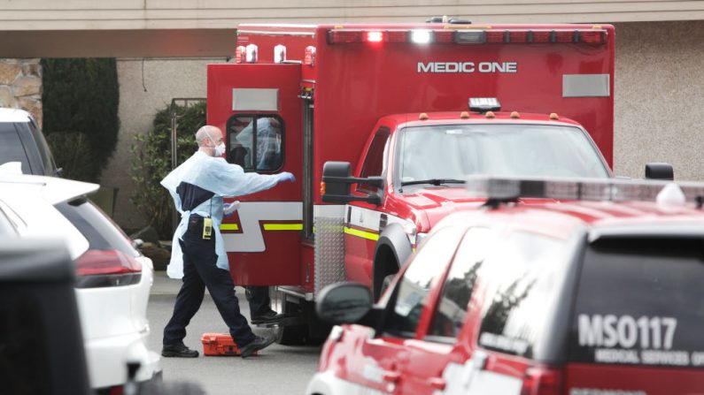 El personal de la ambulancia se prepara para transportar a un paciente del asilo del Life Care Center donde algunos pacientes han muerto a causa de COVID-19 en Kirkland, Washington el 5 de marzo de 2020. (JASON REDMOND/AFP/ Getty Images)
