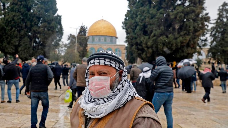 Un hombre palestino que lleva una máscara protectora como medida de protección contra el coronavirus COVID-19, está de pie frente a la mezquita de la Cúpula de la Roca dentro del recinto de las mezquitas de Al-Aqsa en la Ciudad Vieja de Jerusalén (Israel), antes de las oraciones del viernes, el 6 de marzo de 2020. (AHMAD GHARABLI/AFP vía Getty Images)