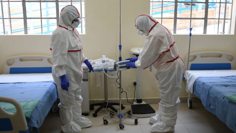 Trabajadores de la salud kenianos llevan trajes protectores durante una demostración para la preparación de cualquier posible caso de coronavirus en el hospital del distrito de Mbgathi en Nairobi (Kenia) el 6 de marzo de 2020. (SIMON MAINA/AFP/Getty Images)