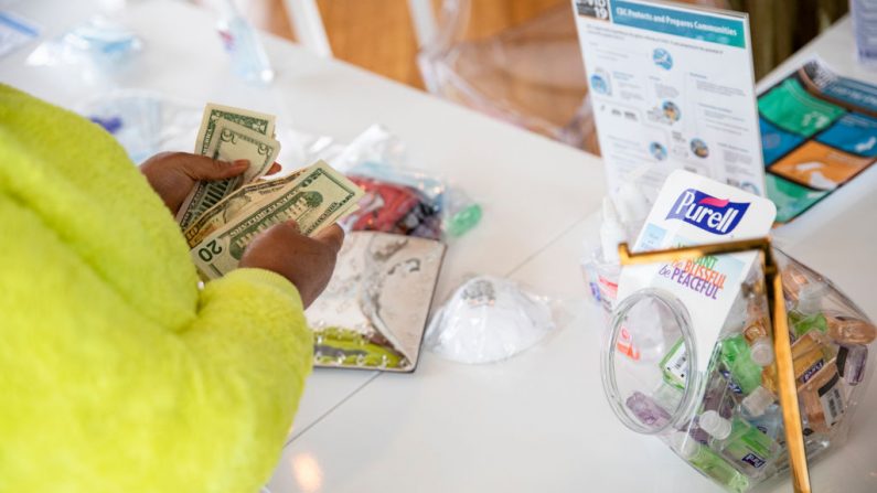 Un cliente cuenta su dinero para comprar máscaras faciales N95 y desinfectante de manos en una tienda eventual por coronavirus en el barrio NoMa de Washington, DC el 6 de marzo de 2020.
