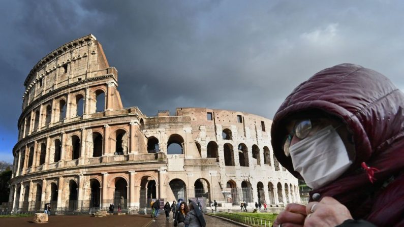 Un hombre con una máscara protectora pasa por el Coliseo de Roma, el 7 de marzo de 2020, en medio del temor a la epidemia de COVID-19. (ALBERTO PIZZOLI/AFP/ Getty Images)