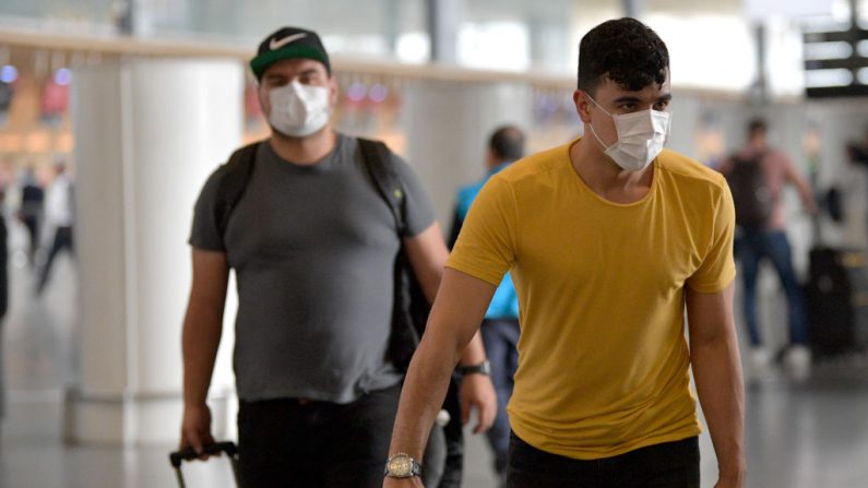 La gente usa máscaras protectoras como medida preventiva contra la propagación del nuevo Coronavirus, COVID-19, en el aeropuerto El Dorado de Bogotá el 7 de marzo de 2020. (Foto de Raúl ARBOLEDA/AFP vía Getty Images)
