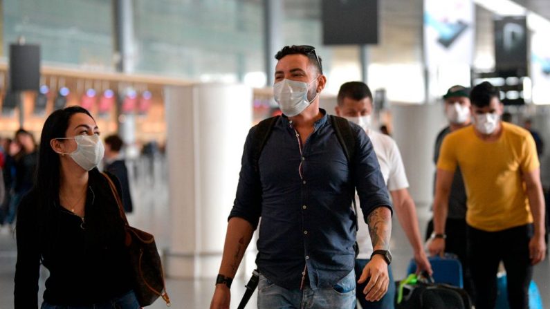 La gente usa máscaras protectoras como medida preventiva contra la propagación del nuevo Coronavirus, COVID-19, en el aeropuerto El Dorado de Bogotá el 7 de marzo de 2020. (Foto de Raúl ARBOLEDA/AFP vía Getty Images)
