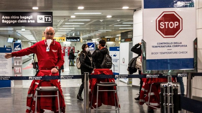 El personal de un aeropuerto dirige a los pasajeros en el aeropuerto de Fiumicino de Roma (Italia) el 7 de marzo de 2020 a pasar por el control de la temperatura corporal para evitar la propagación del nuevo coronavirus. (LAURENT EMMANUEL/AFP vía Getty Images)