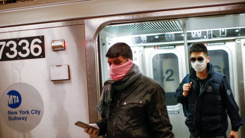 Dos hombres llevan protectores faciales en el metro, el 8 de marzo de 2020 en la ciudad de Nueva York. (KENA BETANCUR/AFP vía Getty Images)