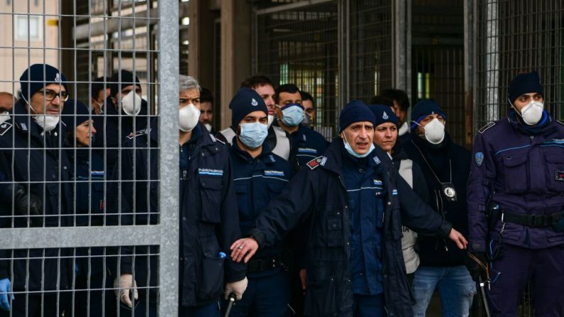 La policía penitenciaria hace guardia en la entrada de la prisión de Sant'Anna en Módena, Emilia-Romaña, en una de las zonas rojas de cuarentena de Italia, el 9 de marzo de 2020. (Piero Cruciatti/AFP vía Getty Images)
