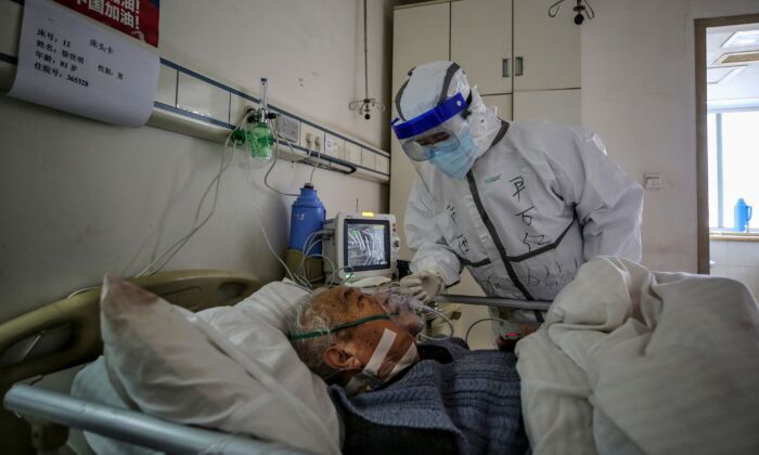 Un integrante del personal médico habla con un paciente infectado por coronavirus COVID-19 en el Hospital de la Cruz Roja en Wuhan, China, el 10 de marzo de 2020. (STR/AFP vía Getty Images)
