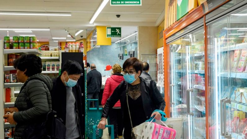 Las personas, algunas de ellas con máscaras protectoras ante el nuevo brote de coronavirus, hacen las compras en un supermercado del barrio de Usera en Madrid, España, el 10 de marzo de 2020. (OSCAR DEL POZO/AFP vía Getty Images)