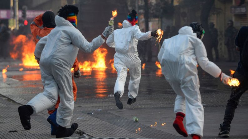Manifestantes lanzan cócteles molotov a la policía antidisturbios durante las protestas contra el gobierno de Sebastián Piñera en su segundo aniversario, el 11 de marzo de 2020 en Santiago de Chile, Chile. (Claudio Santana/Getty Images)