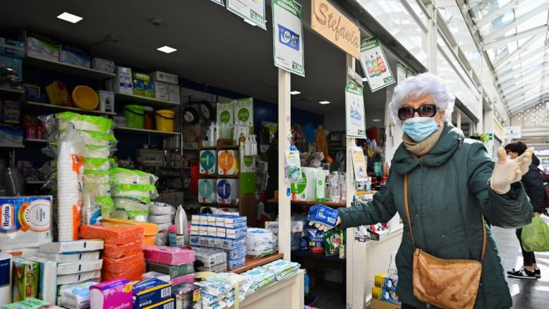 Una anciana compra en un puesto de artículos para el hogar de un mercado de Roma el 12 de marzo de 2020. (ALBERTO PIZZOLI/AFP vía Getty Images)