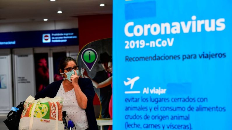 Un pasajero con una máscara facial como medida preventiva contra la propagación del coronavirus COVID-19 llega al Aeropuerto Internacional de Ezeiza en Buenos Aires, el 12 de marzo de 2020. (Foto de RONALDO SCHEMIDT/AFP vía Getty Images)
