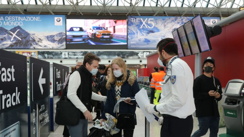 La seguridad del aeropuerto de Fiumicino comprueba que los pasajeros han firmado la autodeclaración que les permite saltar la cuarentena y viajar el 12 de marzo de 2020 en Roma, Italia. (Marco Di Lauro/Getty Images)